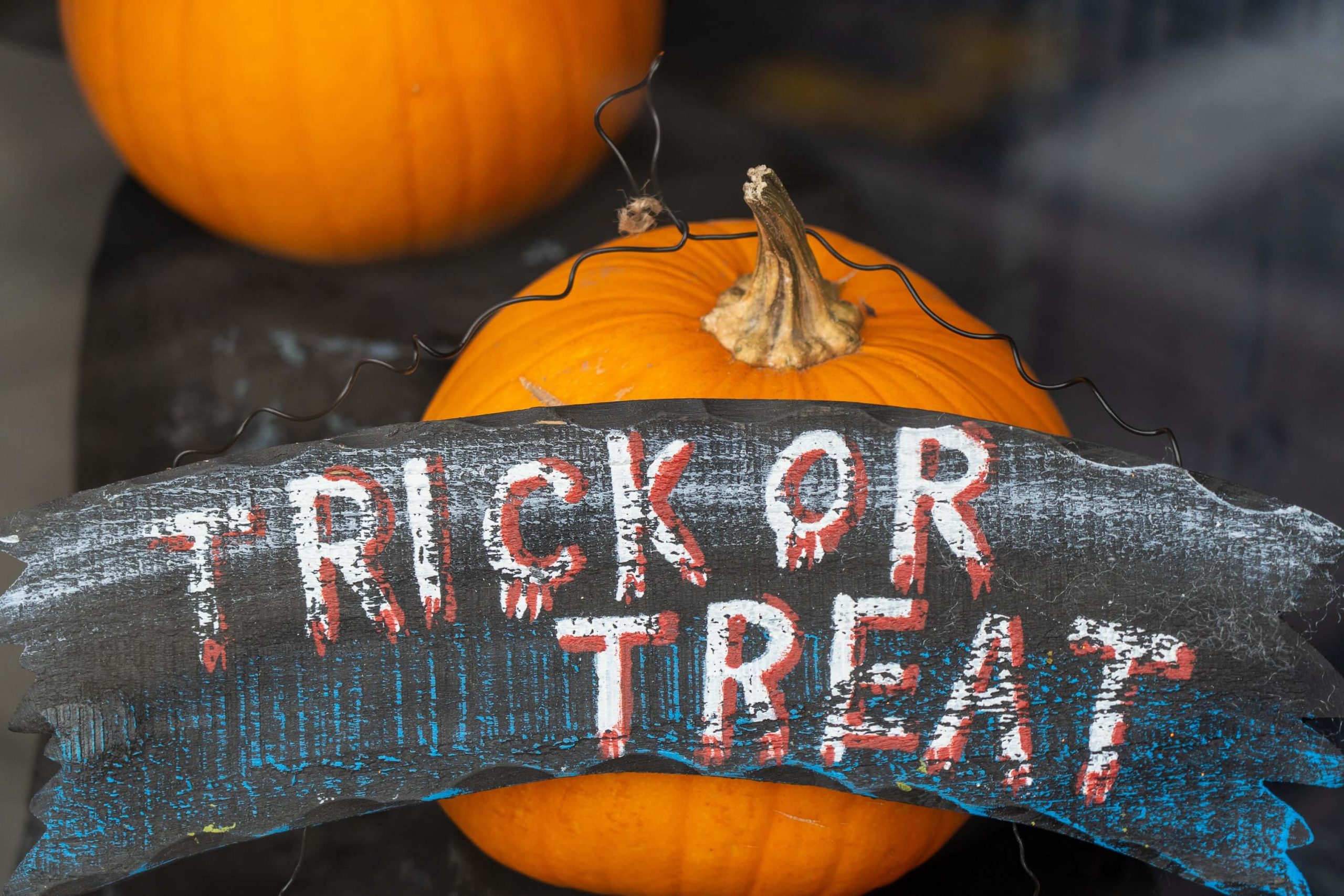 pumpkins with a trick or treat sign in front
