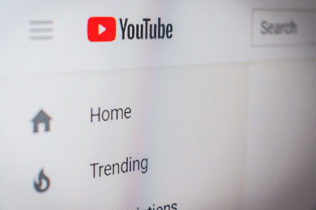 An extreme close up of a YouTube screen, showing the home and trending tabs